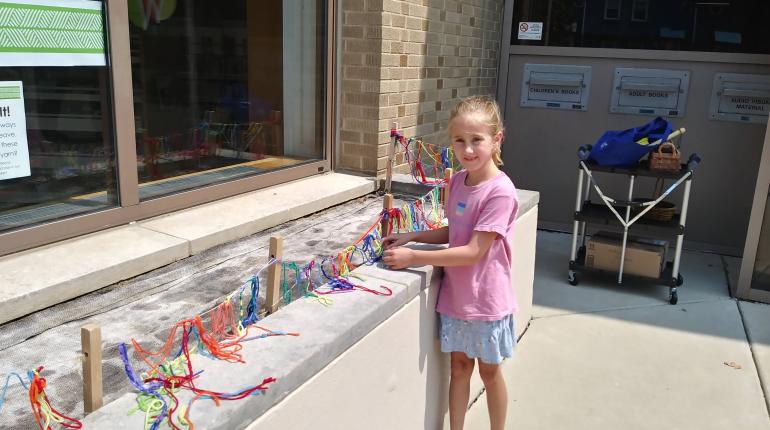 A child outside working with the things in the Maker Garden