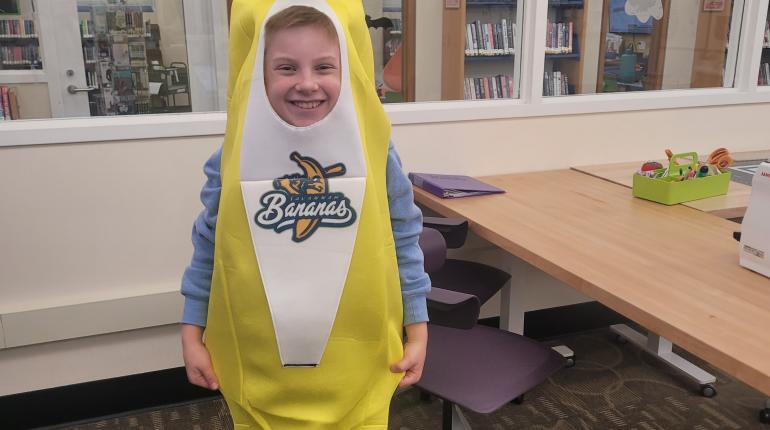 A young patron in his banana Halloween costume with a logo heat pressed onto the center of it.